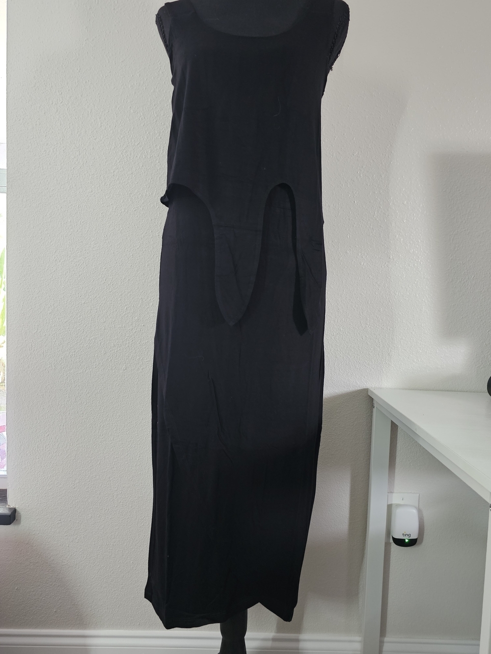 Black sleeveless midi dress with a distinctive asymmetrical, shark-bite